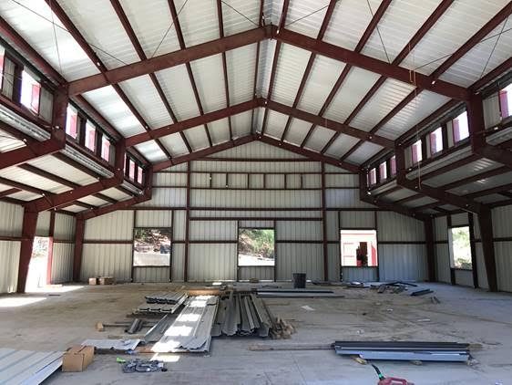 Raised center aisle barn with lean-tos, cupolas and natural ridge ventilation.