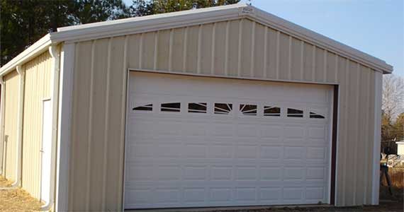 Personal garage and shop with matching trim and a walk door.